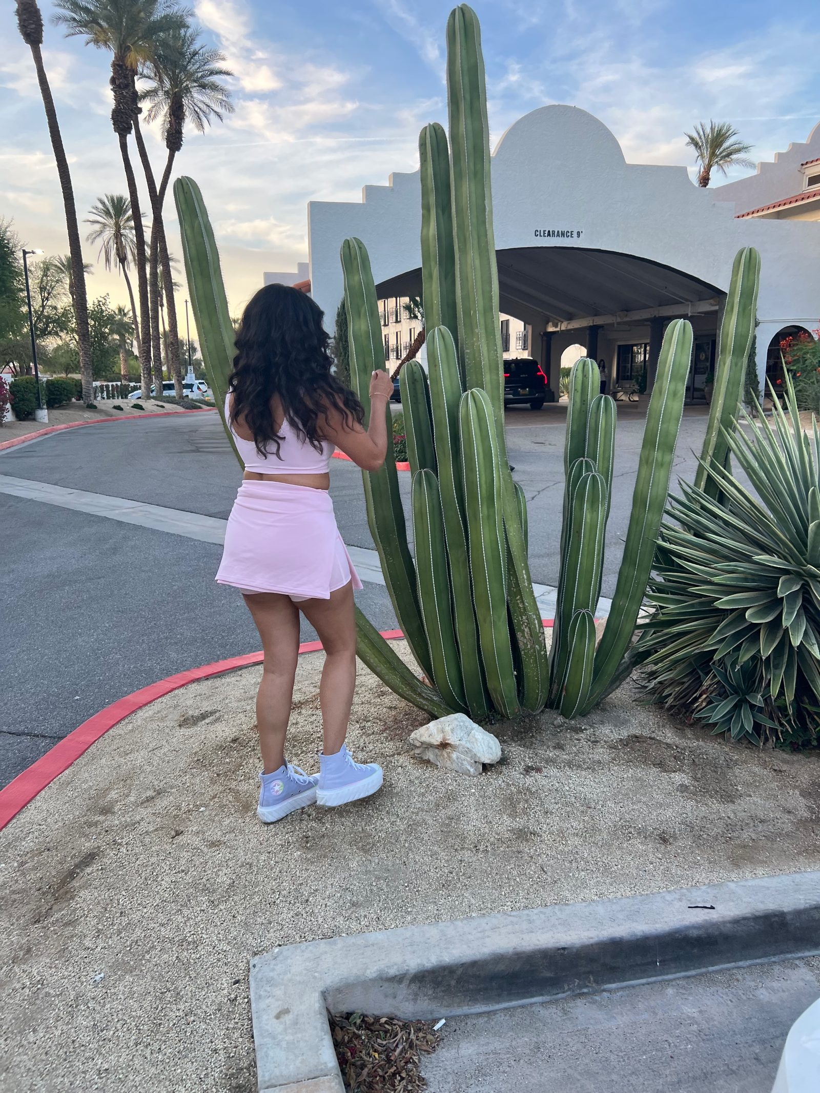 Janet from behind in a pink set looking up at a giant cactus at the Embassy Suites entrance