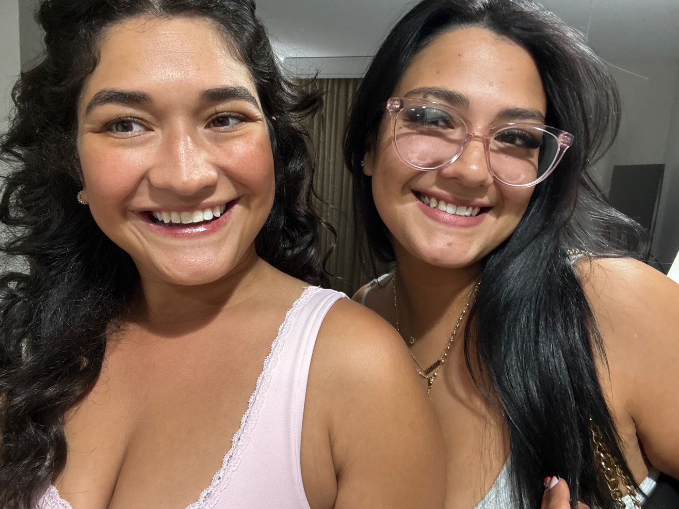 Janet and Victoria smiling in a close selfie, hair and makeup done, ready to go