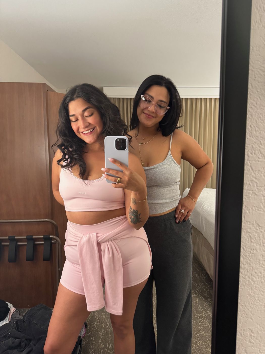 Janet and Victoria taking a mirror selfie in their Embassy Suites room, Janet in a pink two-piece set